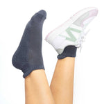 Dark blue bamboo socks with sneaker on one foot