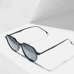 Dark black sunglasses on angled white surface