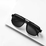 Retro style dark shade sunglasses on white surface