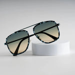 Green Mystic Meridian Shade sunglasses on white stand